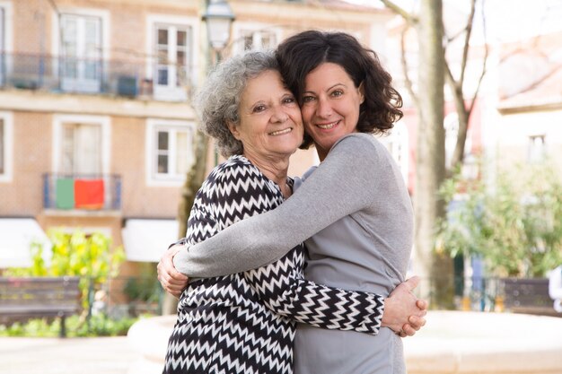 Mujer joven positiva feliz que presenta con su mamá