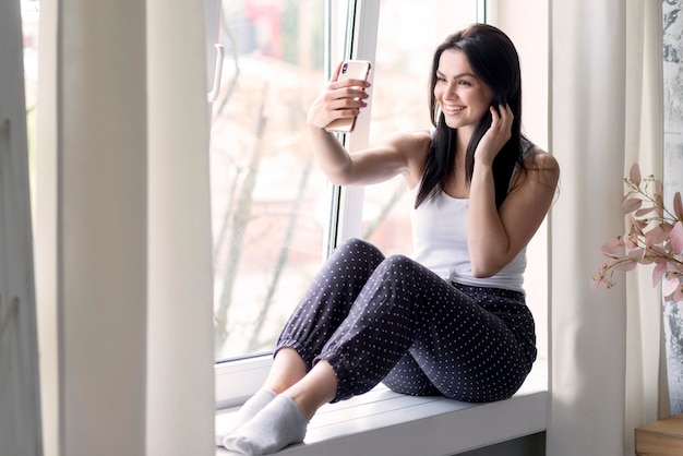 Mujer joven positiva tomando un selfie