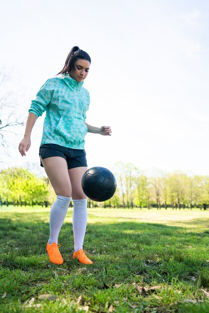 Mujer joven practicando habilidades de fútbol con balón