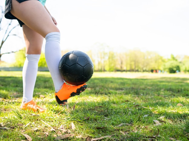 Foto gratuita mujer joven practicando habilidades de fútbol con balón