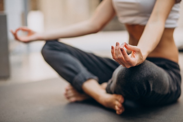 Mujer joven practicando yoga en casa