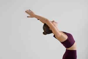 Foto gratuita mujer joven practicando yoga para el equilibrio de su cuerpo