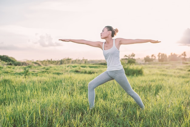 Mujer joven practicando yoga por la mañana