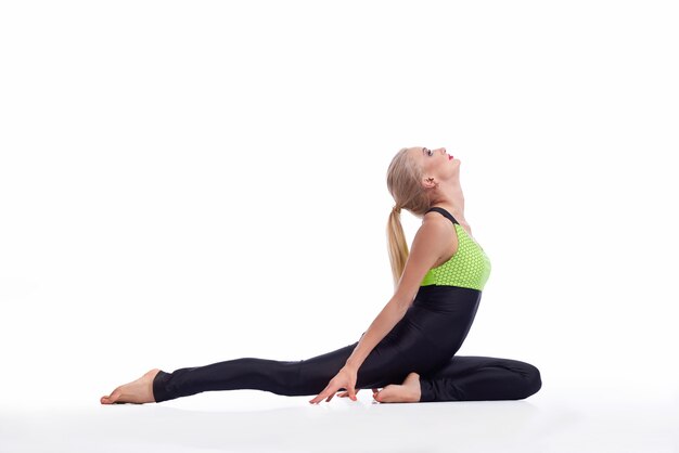 mujer joven practicando yoga sentada en el suelo estirando la espalda