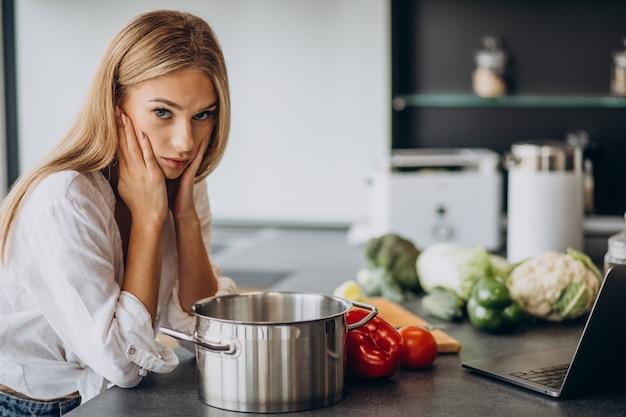 Mujer joven preparando comida en la cocina