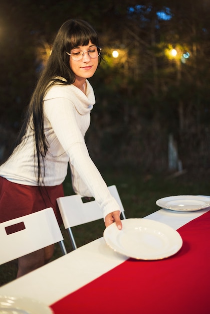 Mujer joven preparando la mesa para la cena de navidad