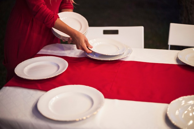 Mujer joven preparando la mesa para la cena de navidad