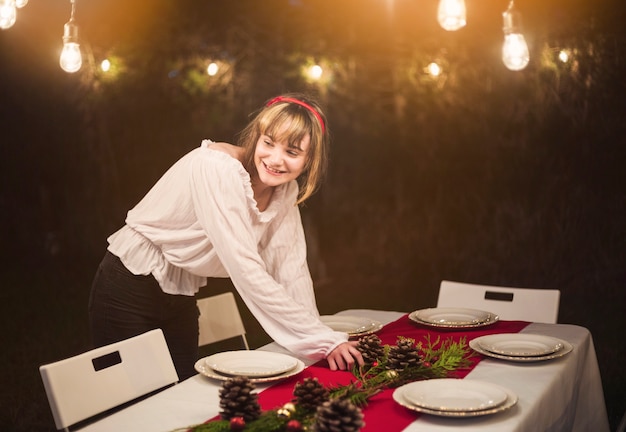 Mujer joven preparando la mesa para la cena de navidad