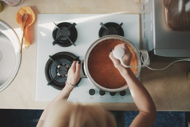 Mujer joven preparando sopa de calabaza