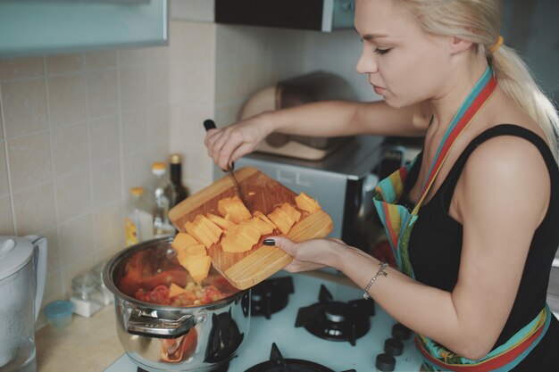 Mujer joven preparando sopa de calabaza