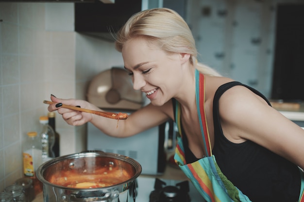 Mujer joven preparando sopa de calabaza