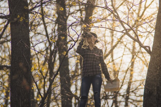 Mujer joven con prismáticos y mapa al aire libre