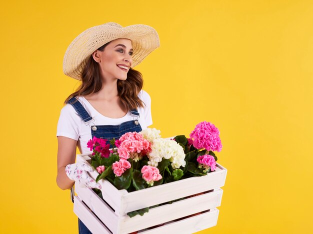 Mujer joven, proceso de llevar, caja de madera, con, hermoso, flores