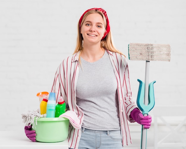 Mujer joven con productos de limpieza