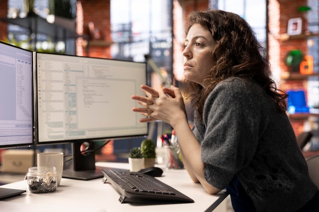 Mujer joven programando código de software en su computadora