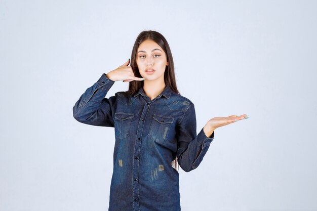 Mujer joven promocionando algo y pidiendo pedirlo.