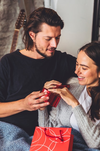 Foto gratuita mujer joven que abre la pequeña caja de regalo