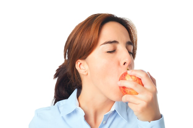 Mujer joven que come una manzana roja