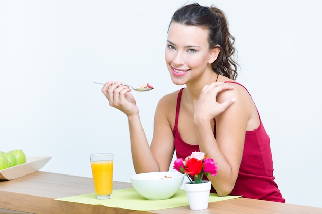 Mujer joven que desayuna en el país