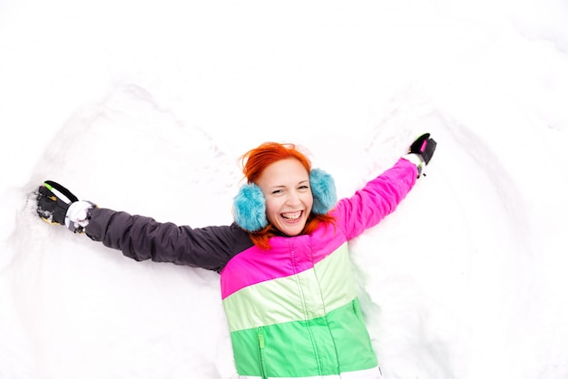 Mujer joven que se divierte en nieve