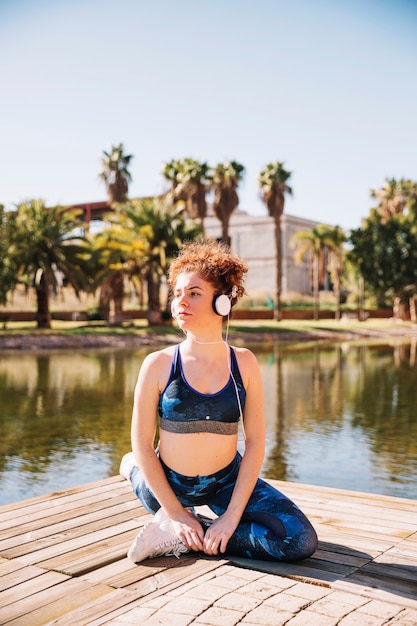 Mujer joven que ejercita cerca del agua