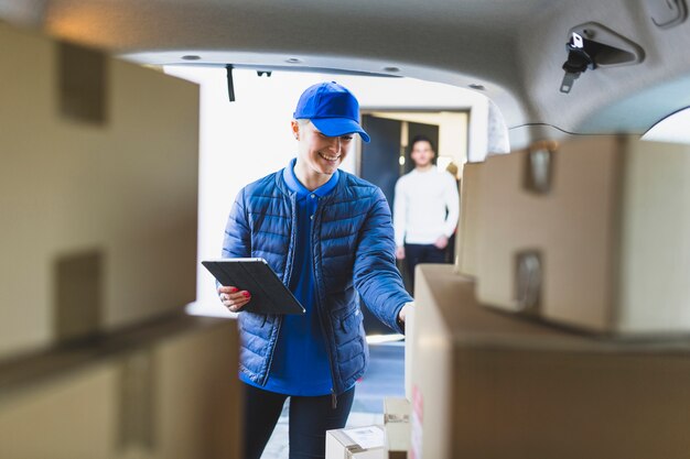 Mujer joven que entrega el correo al cliente