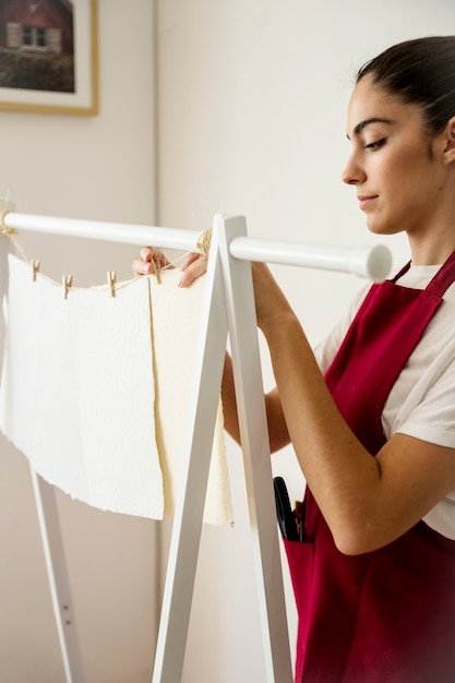 Foto gratuita mujer joven que entrega papel blanco hecho a mano