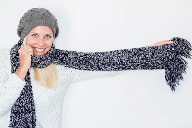 Foto gratuita mujer joven que envuelve en bufanda y sonriendo