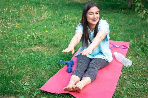 Una mujer joven que se extiende haciendo ejercicios de fitness en Green Park