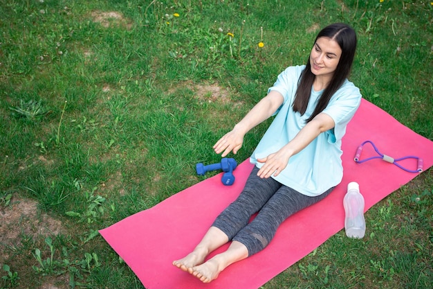 Una mujer joven que se extiende haciendo ejercicios de fitness en Green Park