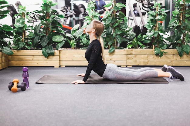 Foto gratuita mujer joven que hace entrenamiento en la estera del ejercicio