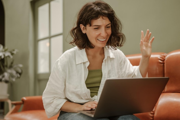 Mujer joven que mira la computadora portátil