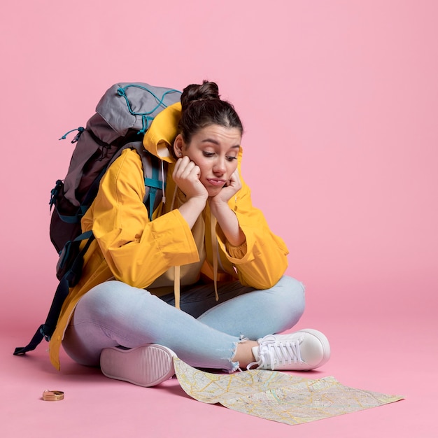 Mujer joven que mira en un mapa