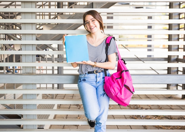 Mujer joven que muestra el libro de texto