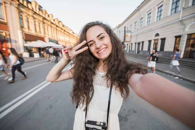 Mujer joven que muestra el signo de la paz