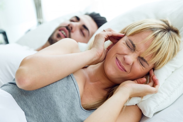 Mujer joven que no puede dormir porque su marido ronca.