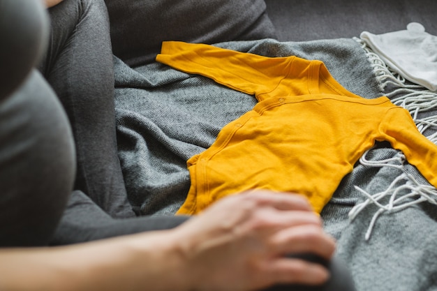 Mujer joven que prepara la ropa para el bebé