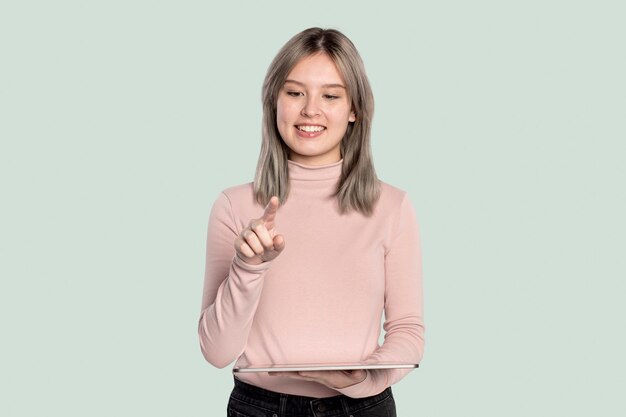 Mujer joven que presenta holograma invisible que se proyecta desde la tecnología avanzada de la tableta