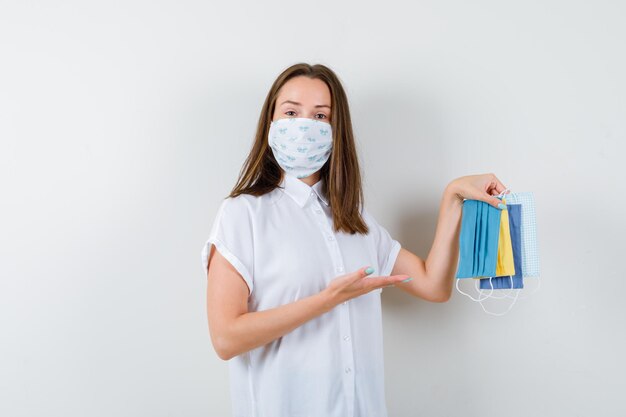 Mujer joven que presenta máscaras médicas