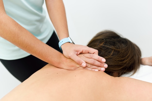 Mujer joven que recibe un masaje de espalda en un centro de spa.