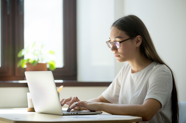 Mujer joven que trabaja en una computadora portátil