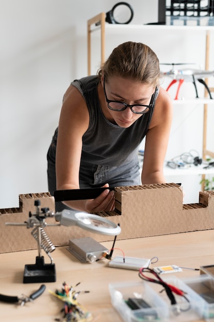 Foto gratuita mujer joven que trabaja en su taller para una invención creativa