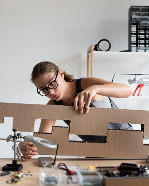 Mujer joven que trabaja en su taller para una invención creativa