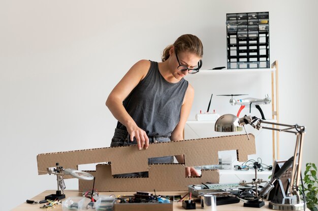 Mujer joven que trabaja en su taller para una invención creativa