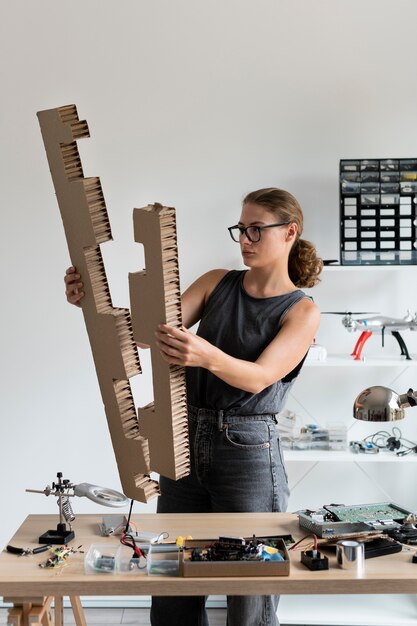 Mujer joven que trabaja en su taller para una invención creativa