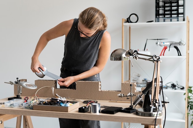 Mujer joven que trabaja en su taller para una invención creativa