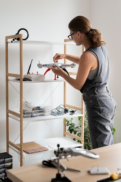 Mujer joven que trabaja en su taller para una invención creativa