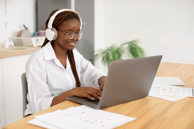 Mujer joven que trabaja con sus auriculares en