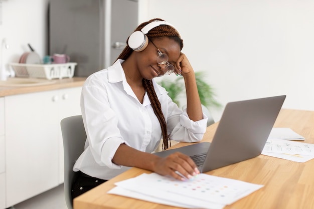 Mujer joven que trabaja con sus auriculares en