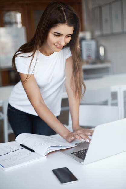 Mujer joven que usa una computadora portátil para comprar cosas geek nuevas en la venta del lunes cibernético para su novio